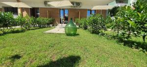 a green vase sitting in the grass in front of a building at Maison Ligea in Sorrento