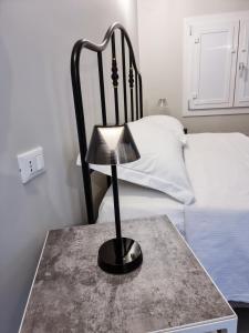 a lamp on a table in front of a bed at Civico 33 in Scalea