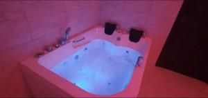 ein rosafarbenes Bad mit einer Badewanne in einem rosa Zimmer in der Unterkunft Deltix Apartments in Vršac