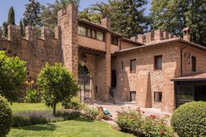 Un viejo edificio de ladrillo con una puerta en un patio. en Residenza Antica Flaminia, en Civita Castellana