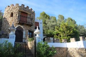 una casa de piedra con una puerta y una valla en EL CASTELLET, en Traiguera