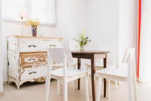 une salle à manger avec une table en bois et des chaises blanches dans l'établissement Regina's Banyuls - comfortable and next to the beach, à Banyuls-sur-Mer