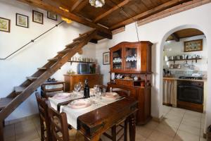 a dining room with a table and a kitchen at Villa Ferulas in Oliena