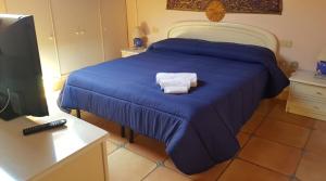 een slaapkamer met een blauw bed met 2 handdoeken erop bij BELVEDERE in La Maddalena