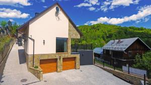 una gran casa blanca con un granero en Domki i Apartamenty Nad Wodospadem, en Szczawnica