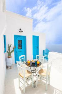 a table and chairs on a patio with blue doors at Nacros Villa Olympos Karpathou in Olympos