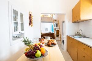 a kitchen with two plates of fruit on a counter at Nacros Villa Olympos Karpathou in Olympos