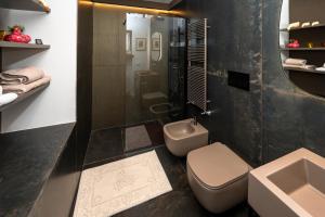 uma casa de banho com um WC, um chuveiro e um lavatório. em Larici Rooms em Roana
