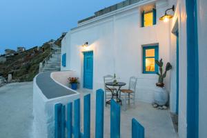 a white house with a blue door and a table at Nacros Villa Olympos Karpathou in Olympos
