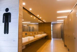 a bathroom with sinks and mirrors and a toilet sign on the wall at Camping & Residence Il Pioppeto in Vasto +37 photos