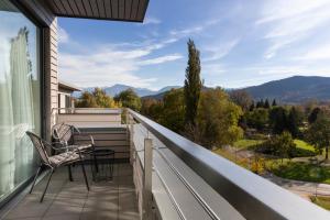 a balcony with chairs and a view of the mountains at Hotel Plattenwirt in Klagenfurt
