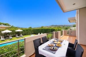 a table with food on the balcony of a house at Klironomos Art Villa in Alikianós