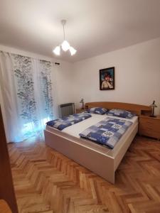 Un dormitorio con una cama grande y suelo de madera. en Apartment Martina, en Rab