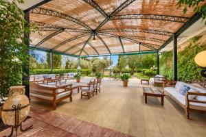 une grande terrasse couverte avec des tables et des chaises. dans l'établissement Son Corb Boutique Hotel, à Cala Bona