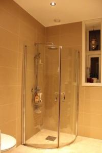 una doccia con porta in vetro in bagno di City Center Apartment ad Ålesund