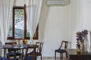 una sala da pranzo con tavolo, sedie e finestra di Relax in giardino a due passi dal porto by Wonderful Italy a Rapallo