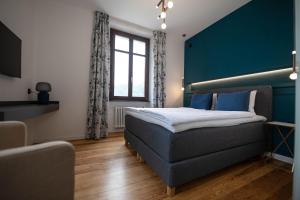 a bedroom with a bed and a blue wall at Arbostora Charme Hotel in Morcote
