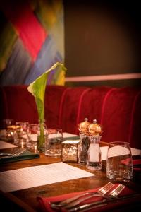 a table with glasses and a vase of flowers on it at Ingleside House in Cirencester