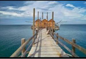 a dock in the water with a house on it at Relais Palazzo del Barone, on Adriatic coast in San Martino in Pensilis