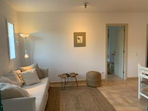 a living room with a couch and a table at Es Cucó in Cala Galdana