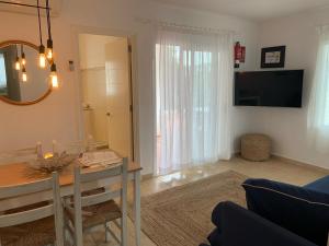 a living room with a table and a dining room at Es Cucó in Cala Galdana