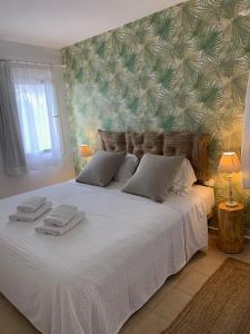 a bedroom with a large white bed with towels on it at Es Cucó in Cala Galdana +37 photos