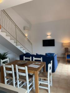 a dining room with a table and chairs and a staircase at Es Cucó in Cala Galdana