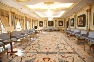 メディナにあるダル アル タクワ ホテルの椅子とシャンデリアが備わる広い客室です。
