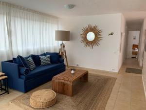 a living room with a blue couch and a table at Es Cucó in Cala Galdana