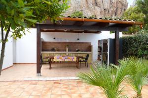 a patio with a table and chairs under a pergola at Villa Benny in San Vito lo Capo