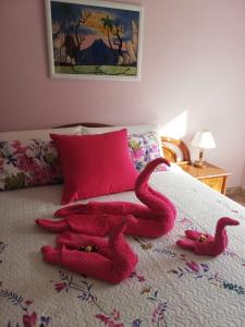un par de serpientes rojas tumbadas en una cama en Casa Rural Pilarraña, en Ujué