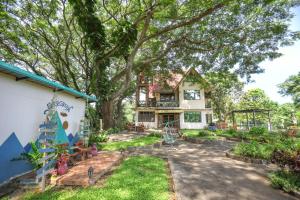 una casa con un grande albero nel cortile di Evergreen Pakchong Home a Pak Chong