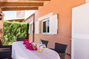 een tafel met bloemen en wijnglazen op een patio bij Casa Mar Blau - mediterranean house in Puigderrós
