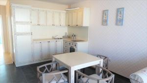 a small kitchen with a table and chairs in it at Captain's Island Deluxe in Chernomorets