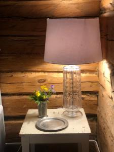uma lâmpada sobre uma mesa com flores sobre ela em Träslottets B&B em Arbrå