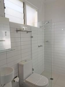 a bathroom with a toilet and a glass shower at Bathurst Explorers Motel in Bathurst