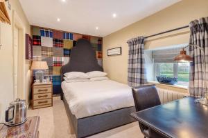 a bedroom with a bed with a headboard and a table at Black Horse Inn in Northallerton