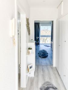 a hallway with white walls and a blue rug at WellenRausch Living "Nock" in Travemünde