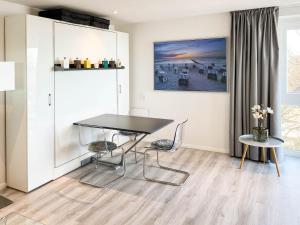 a dining room with a black table and chairs at WellenRausch Living "Nock" in Travemünde