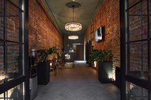 a hallway with brick walls and a table and chairs at Sherwood Hotel in Rostov on Don