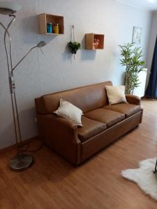Sofá marrón en la sala de estar con lámpara en Chez isa en Saint-Hubert
