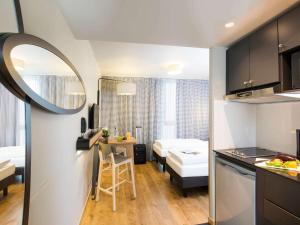 a small apartment with a kitchen and a bedroom at Aparthotel Adagio access München City Olympiapark in Munich