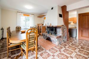 a kitchen with a table and a fireplace at Dom z widokiem na jezioro Tajty - Wilkasy Zalesie in Giżycko