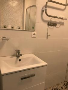 uma casa de banho branca com um lavatório e um espelho em Apart - apartament 12 em Okuninka