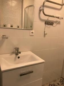 a white bathroom with a sink and a mirror at Apart - apartament 12 in Okuninka
