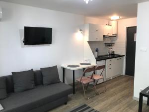 uma sala de estar com um sofá, uma mesa e uma cozinha em Apart - apartament 12 em Okuninka