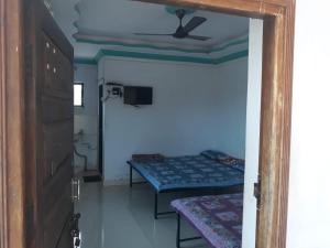 Zimmer mit 2 Betten und einem Deckenventilator in der Unterkunft Mill House in Alibag