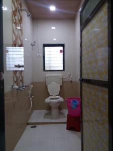 ein Bad mit einem WC und einem Fenster in der Unterkunft Mill House in Alibag