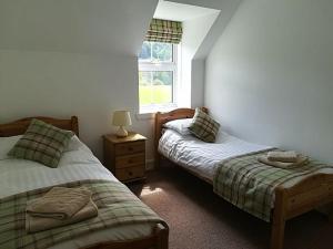 a bedroom with two twin beds and a window at Keeper's Cottage in Lochgilphead