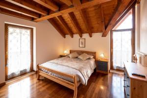 a bedroom with a bed and two windows at Larici Rooms in Roana